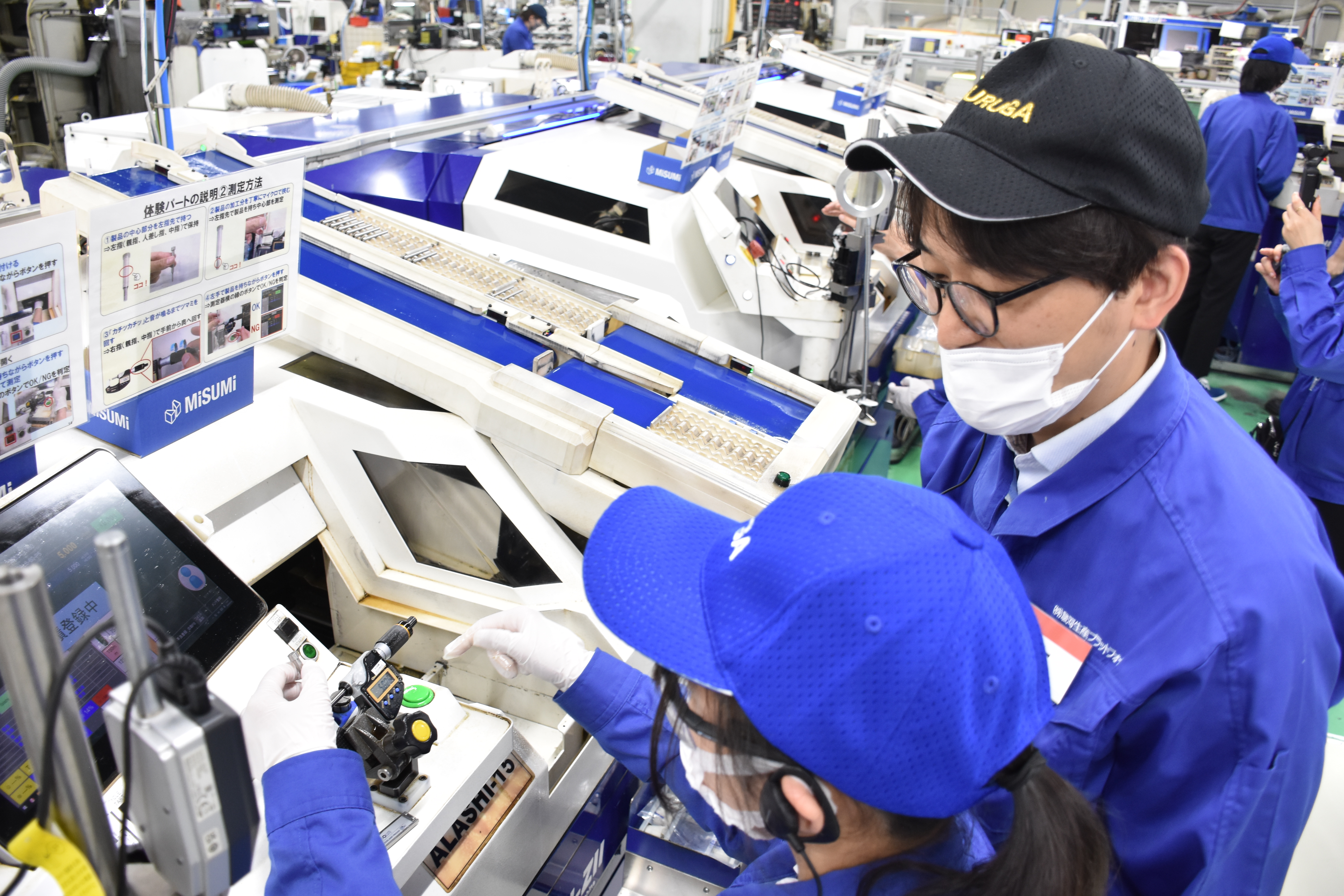 指導員に教わりながら、機械を操作する生徒